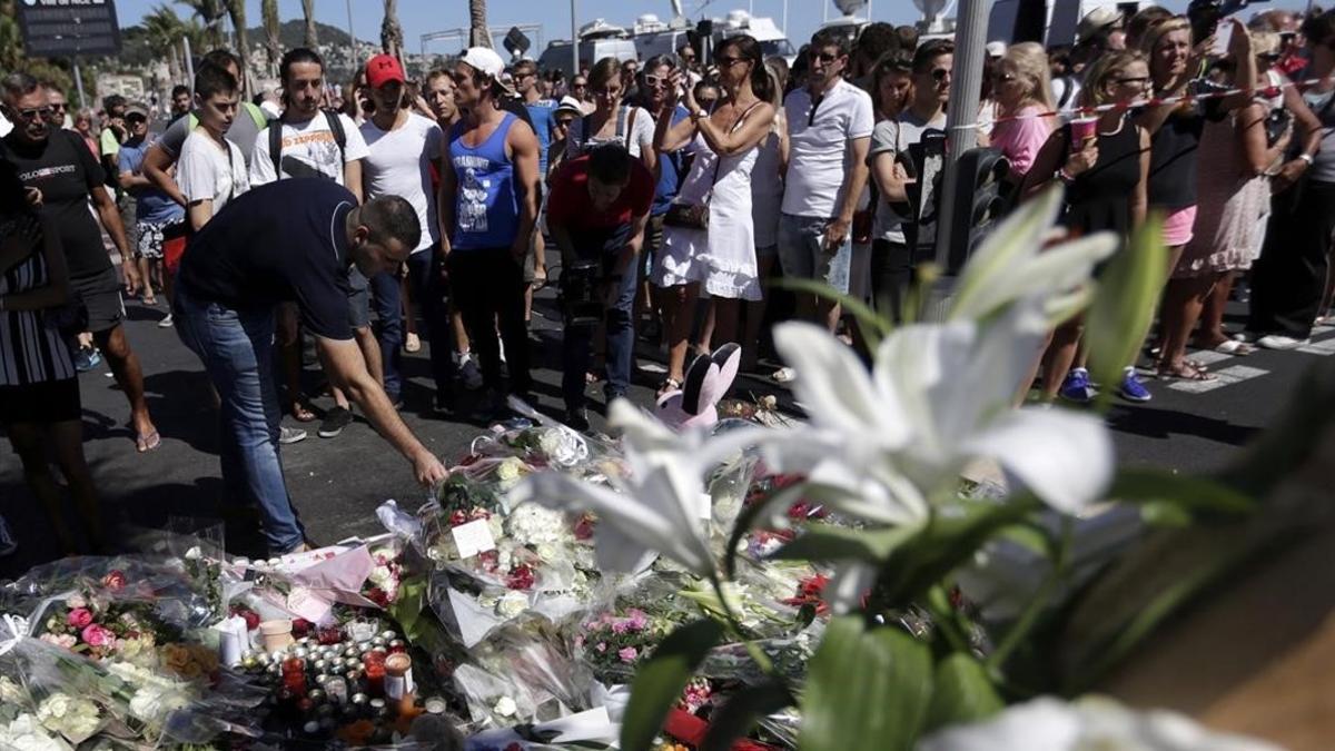 Numerosas personas depositan flores, munecos de peluche y mensajes de condolencia cerca del paseo maritimo de Niza.