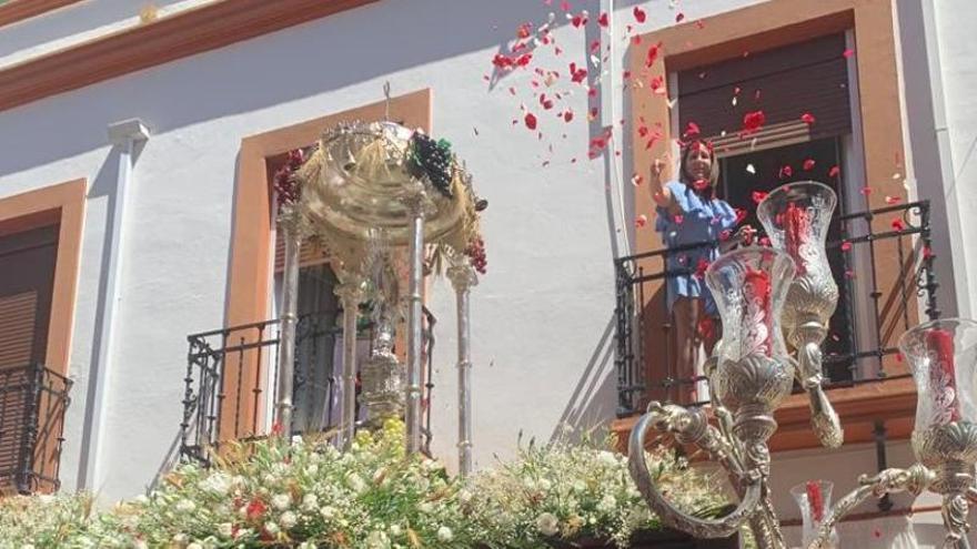 Una vecina arroja pétalos al Santísimo, en la procesión del Corpus de Posadas.