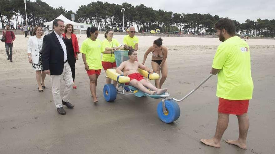 Caballero, con el equipo municipal de baño adaptado en la playa de Samil. // Ricardo Grobas