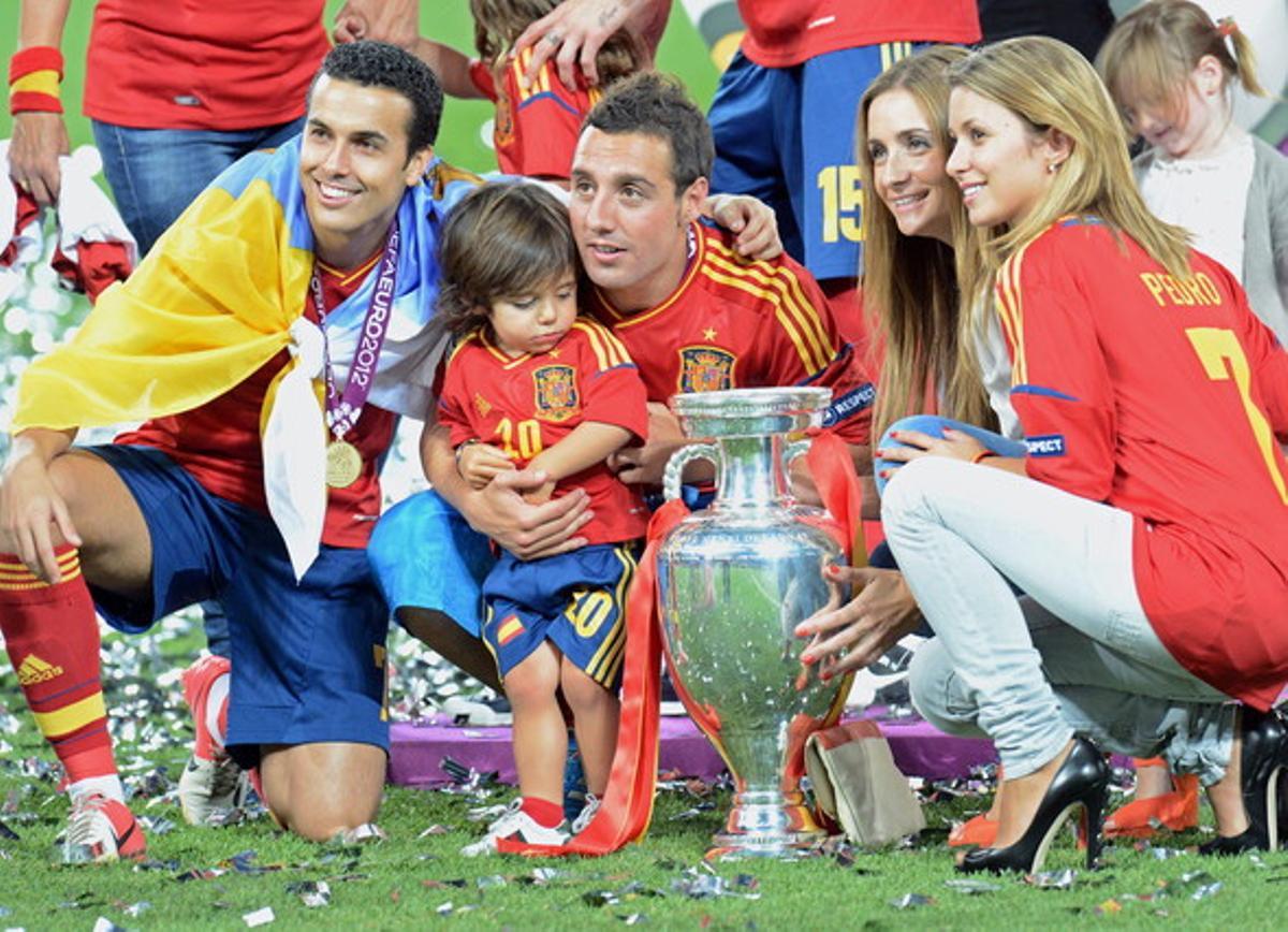 Santi Cazorla (c), su novia Úrsula Santirso (2d), su compañero Pedro Rodríguez (i), y la novia de este Carolina Martín (d) posan con el trofeo de la Eurocopa.
