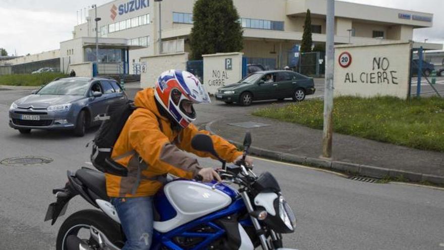 Trabajadores de Suzuki abandonando ayer la fábrica en sus vehículos.