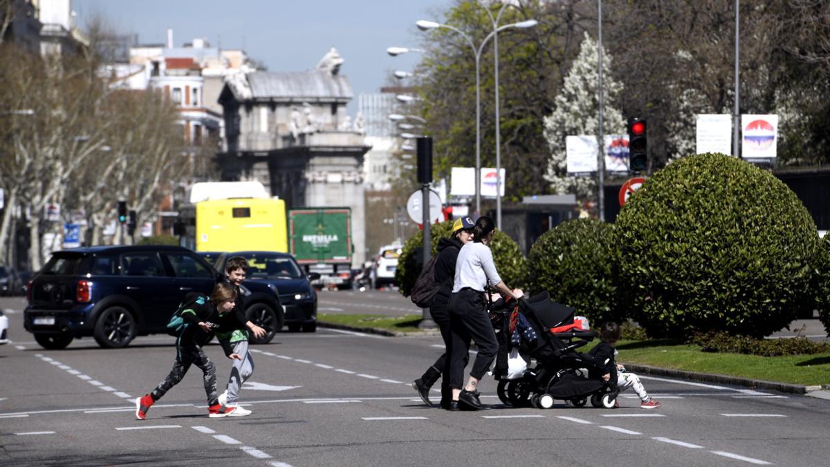 Dos madres pasean con sus hijos frente al Parque del Retiro de Madrid.
