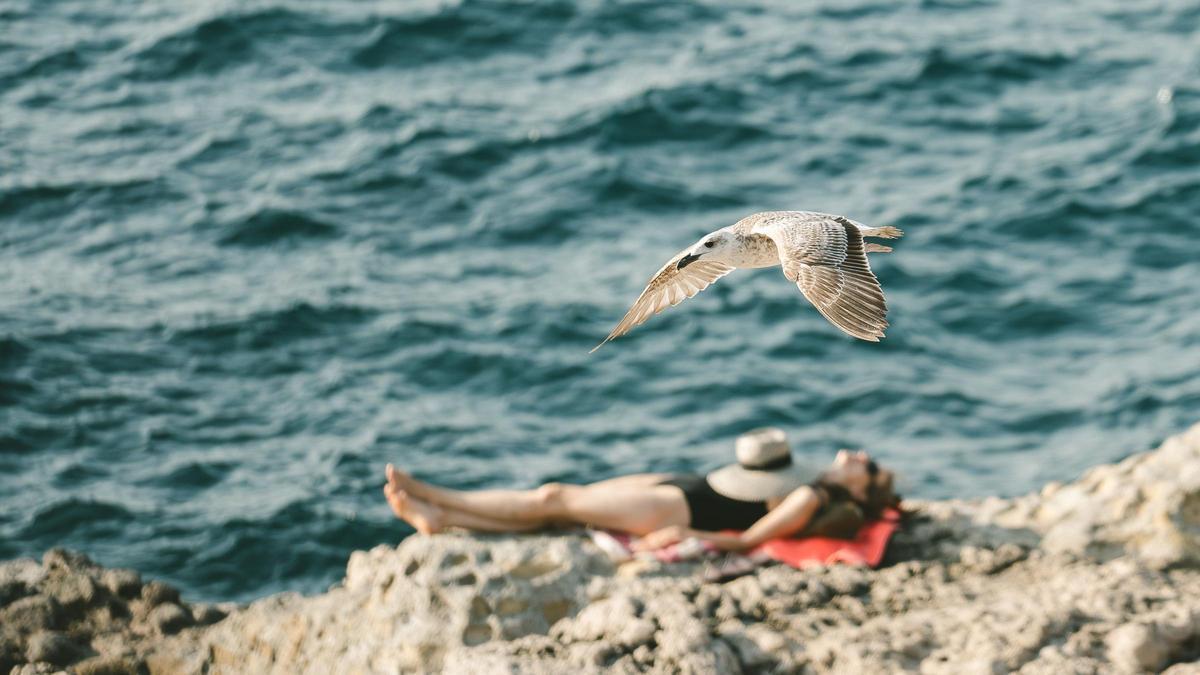 Una mujer tomando el sol en la playa