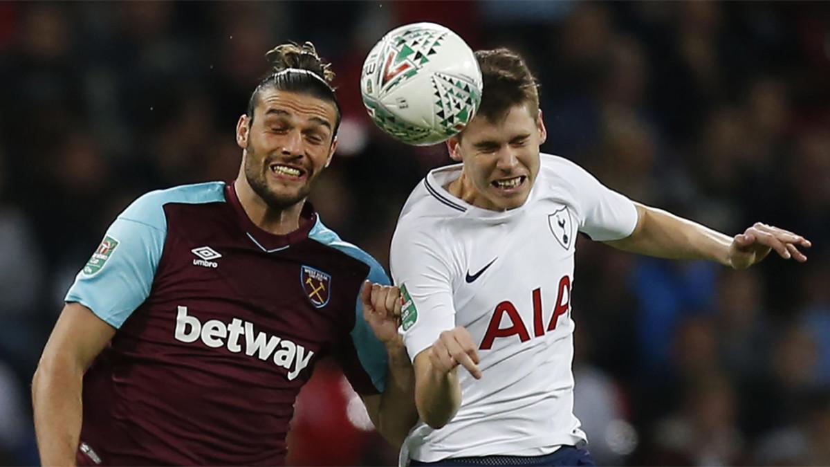 El delantero inglés del West Ham United Andy Carroll (izquierda) disputa el balón con el defensa argentino del Tottenham Hotspur Juan Foyth durante un partido de la Premier League