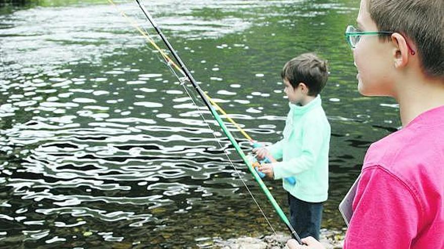 Dos niños pescando en la zona libre de pesca sin muerte de San Tirso.