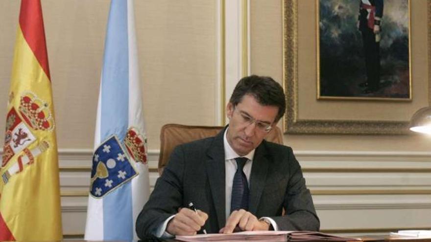 Feijóo, ayer, en su despacho del Pazo de Raxoi, firmando el decreto con los nuevos conselleiros. / x. álvarez