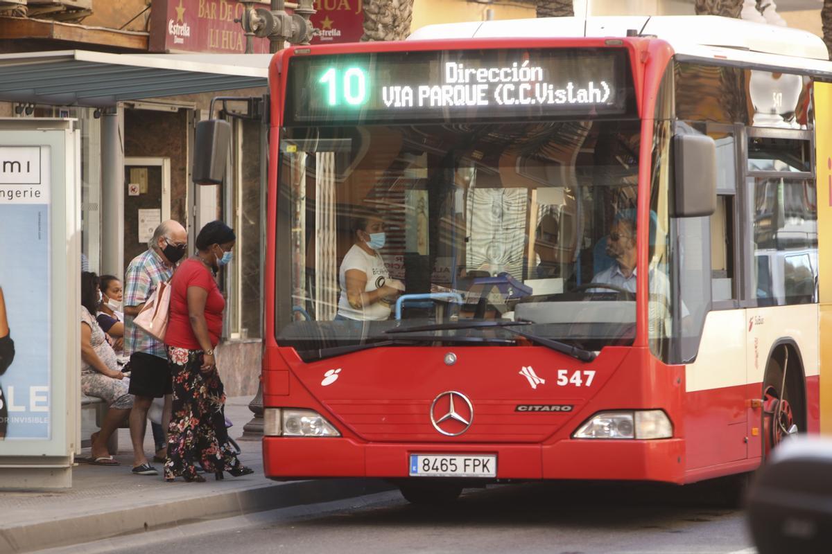 Usuarios esperan a un autobús en una parada del barrio de San Blas, en Alicante