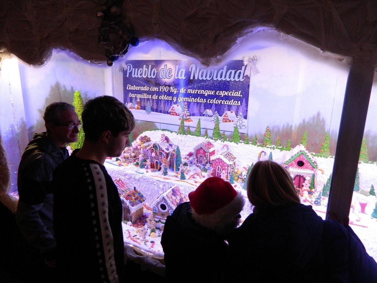 Visitantes contemplan el Pueblo de la Navidad.