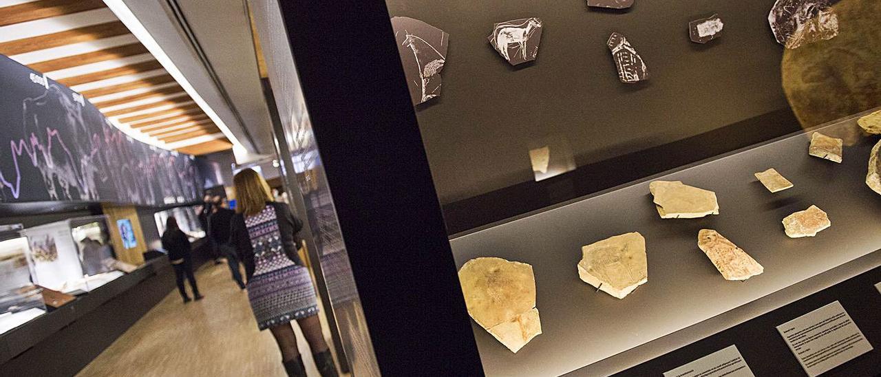 A la izquierda, plaquetas del Parpalló de Gandia en la exposición del Museu de Prehistòria de València. A la derecha, otro aspecto de la muestra. | RAQUEL ABULAILA