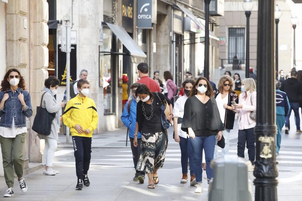 Gente con mascarilla y sin ella por el centro de Gijón.