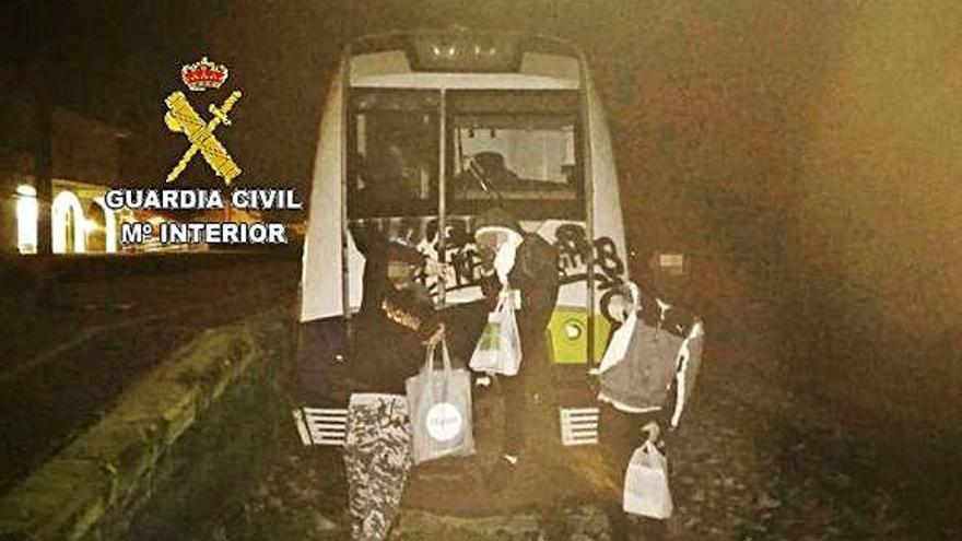 Los tres detenidos, en la foto que se hicieron ante el tren.