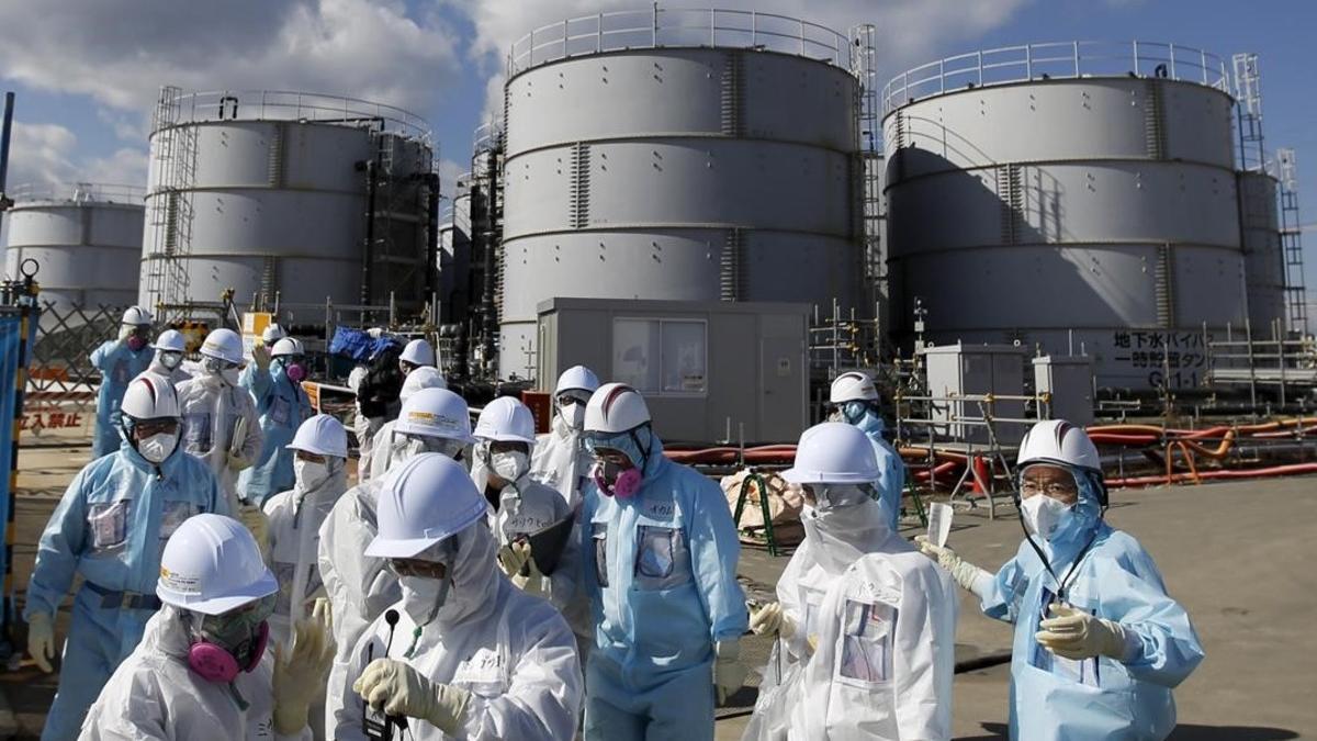 Periodistas protegidos con trajes de protección en una visita a Fukushima.