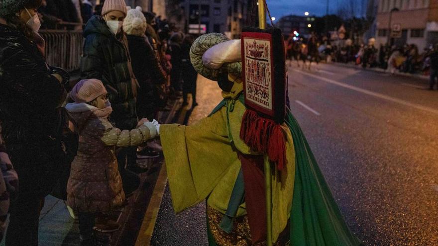 Uno de los Reyes Magos dando un caramelo a una niña durante el desfile del 2022.| E.F.