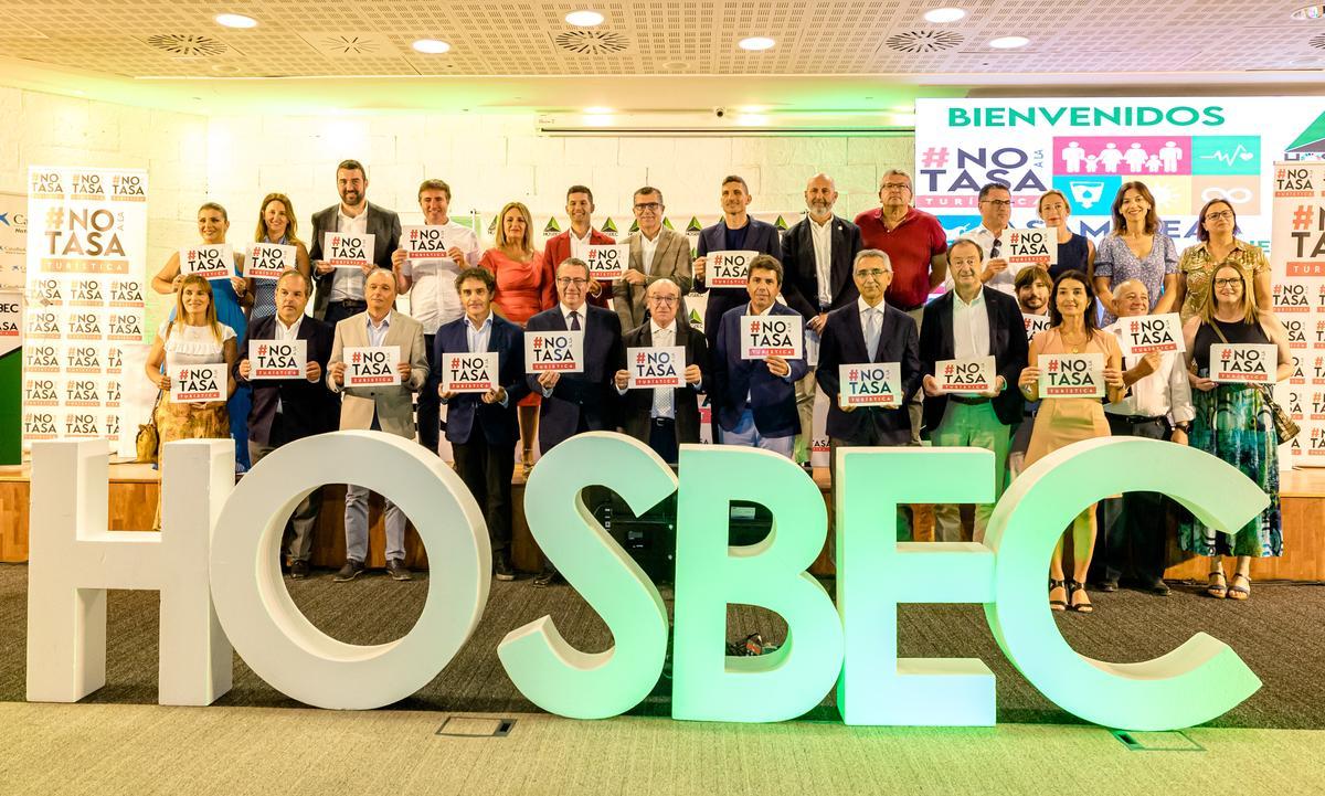 Empresarios y políticos con el cartel de "No a la tasa".