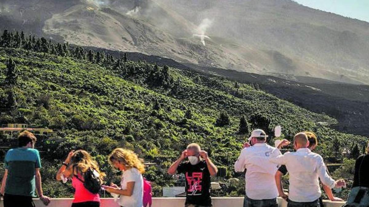 Curiosos acuden a un mirador para observar la erupción del volcán de La Palma.