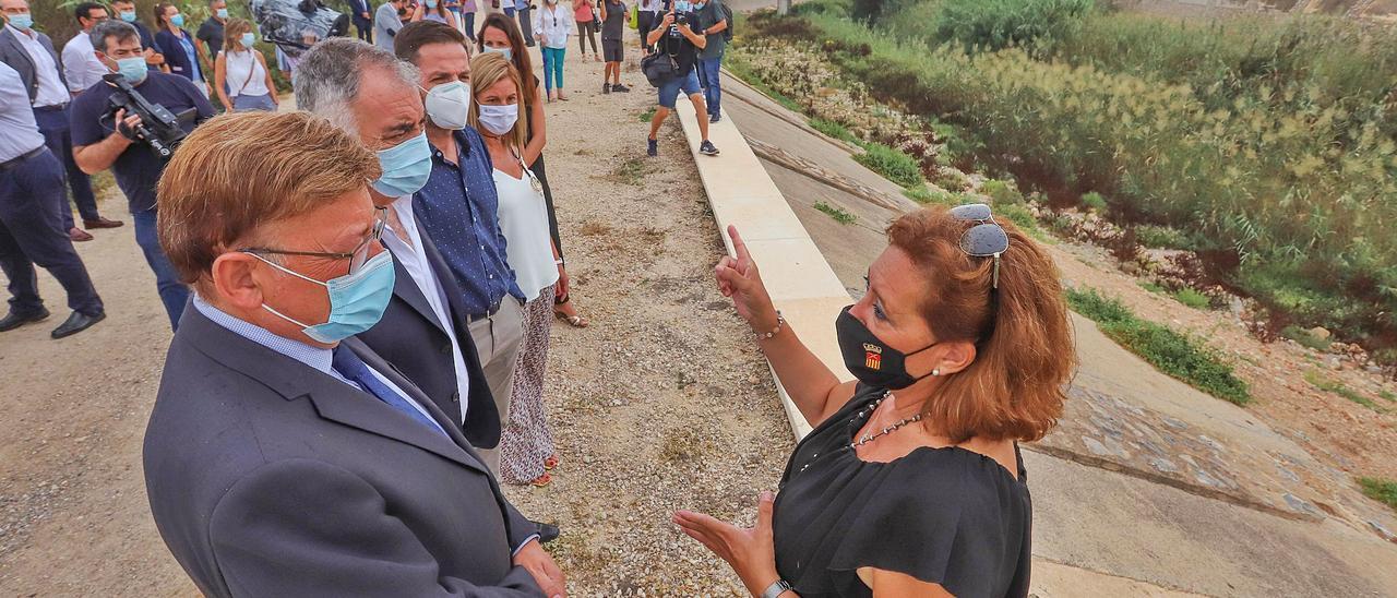 La alcaldesa de Almoradí, María Gómez, charla con el presidente de la Generalitat, Ximo Puig, en la mora del río de Almoradí, en el lugar donde el muro se rompió hace dos años. |