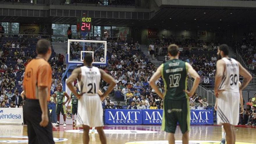 Varios jugadores del Real Madrid y del Unicaja Málaga esperan a que se solucione un problema con el marcador, durante el partido de las semifinales de la Liga ACB disputado esta tarde en el Palacio de los Deportes de la Comunidad de Madrid.