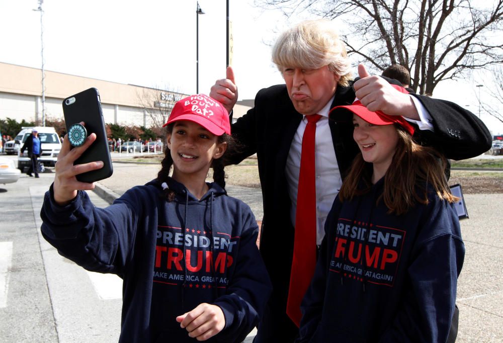 Unas jóvenes seguidoras de Trump se hacen fotos con un imitados en Kentucky, EEUU.