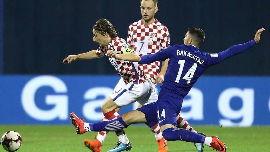 Modric supera a un defensa griego en presencia de Rakitic en un partido de clasificación.