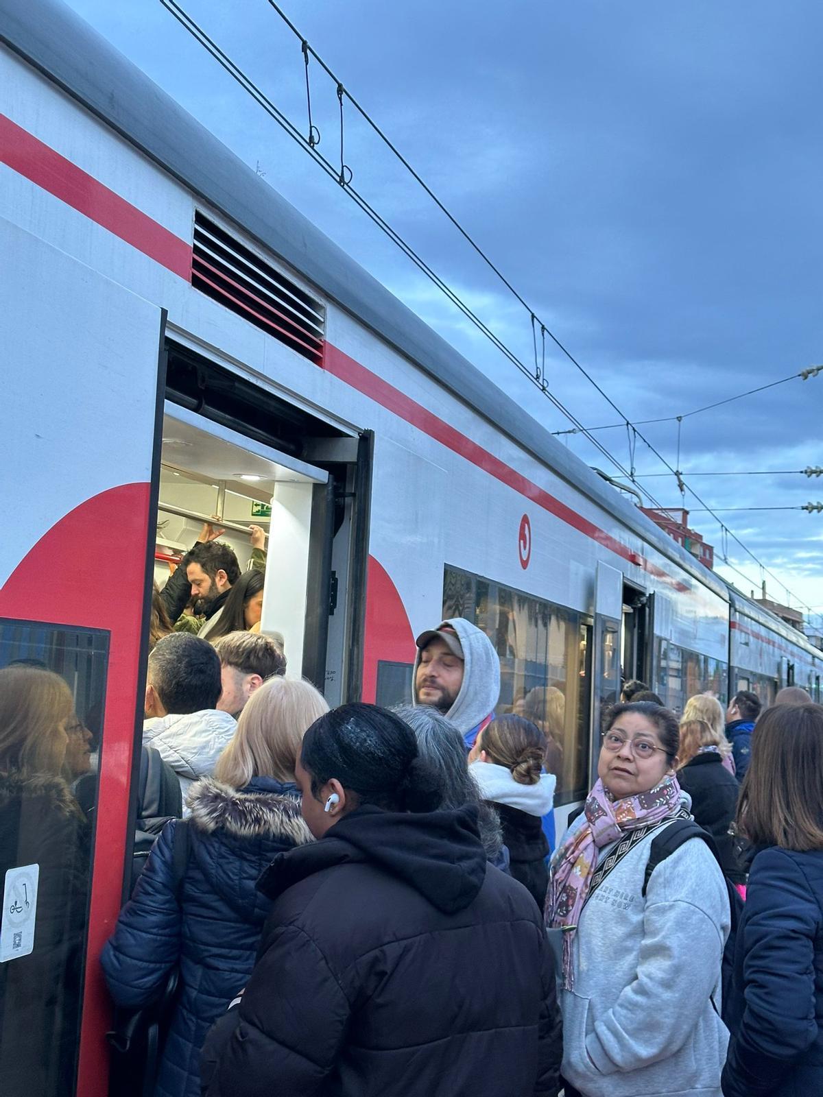 Usuarios intentando entrar al tren en Alfafar.