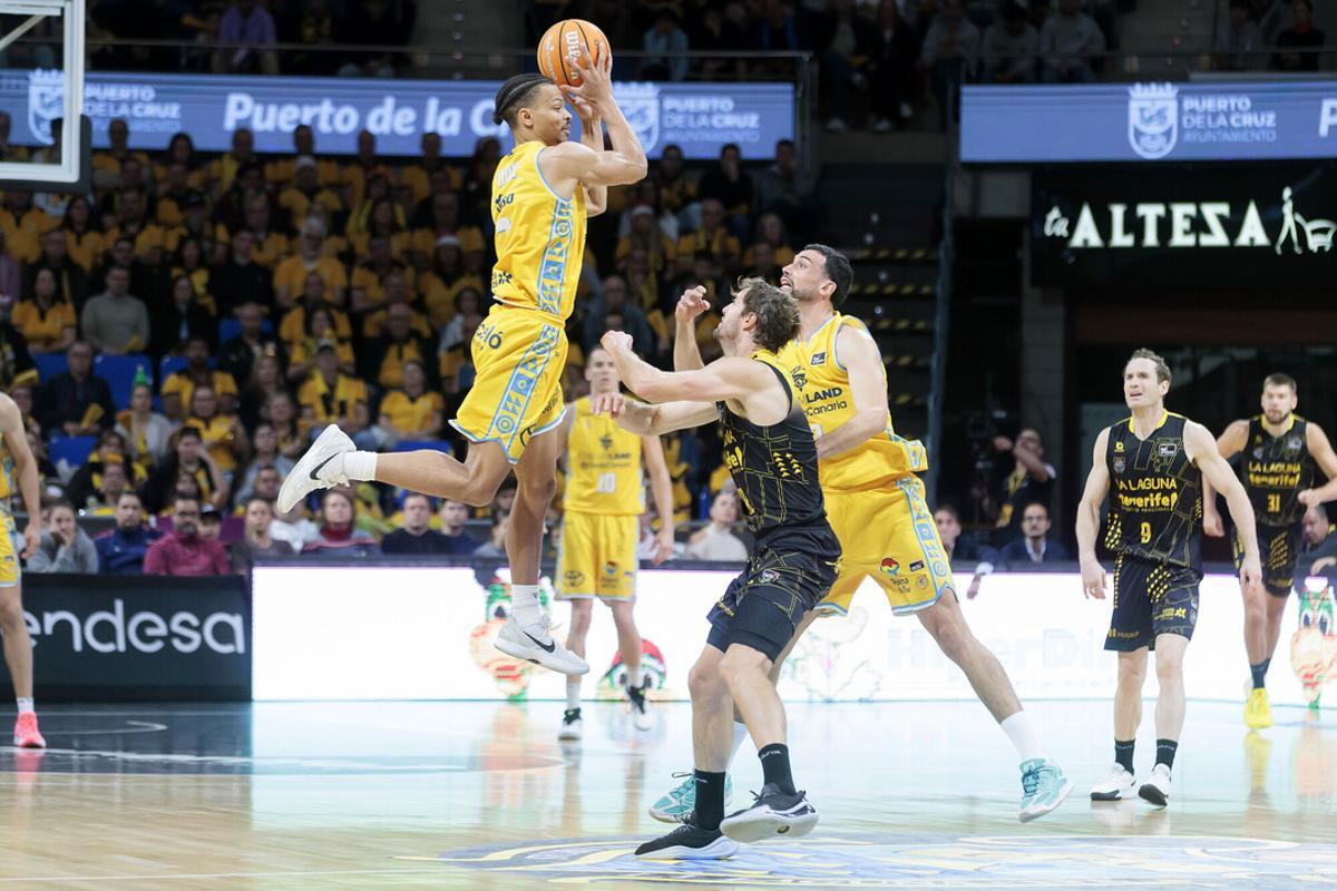 Isaiah Wong, en el aire, busca a algún compañero mientras es defendido por Doornekamp en el derbi de esta temporada en La Laguna.