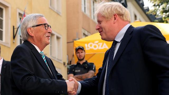Jean-Claude Juncker (iz.) saluda a Boris Johnson.