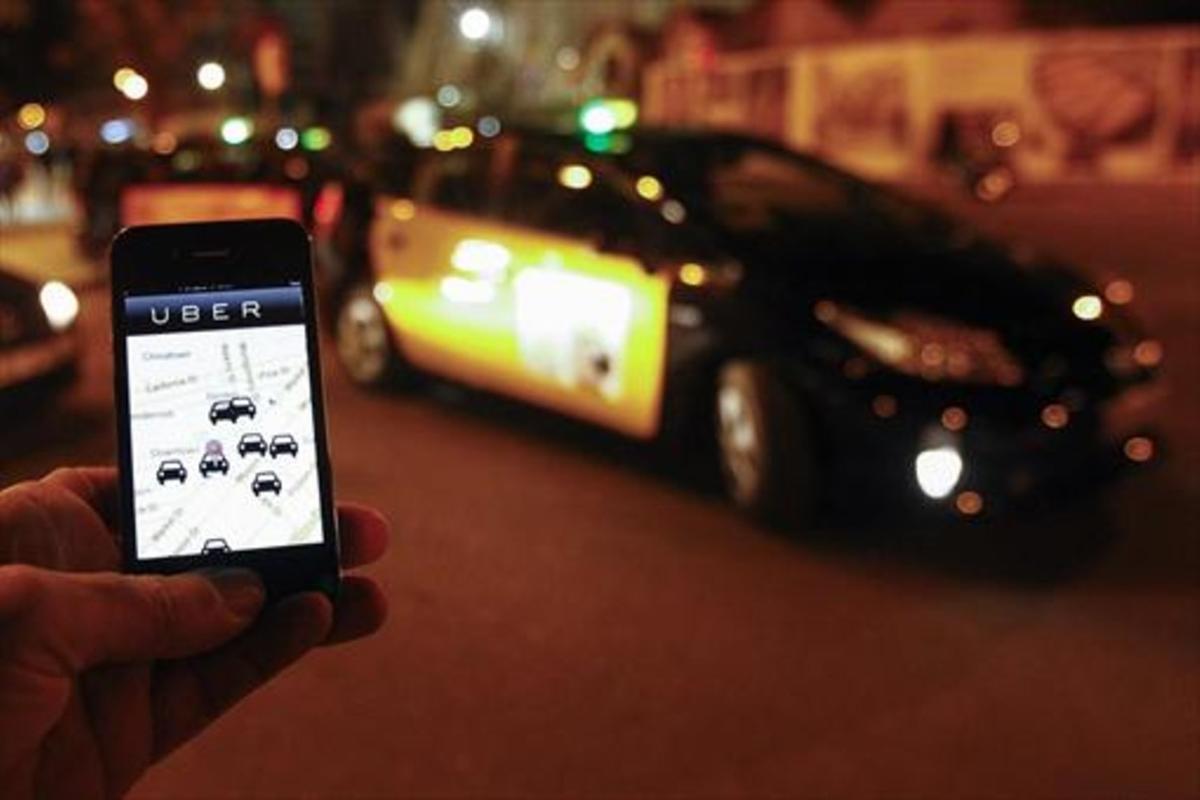 Un usuario consulta la aplicación de Uber junto a la Sagrada Família, en diciembre del 2014.