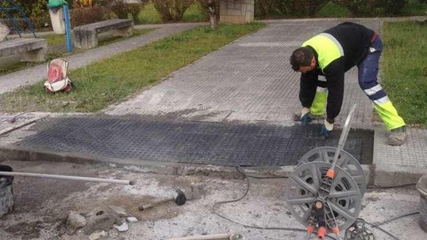 Operarios rebajan la acera en el barrio cangués de Contranquil.