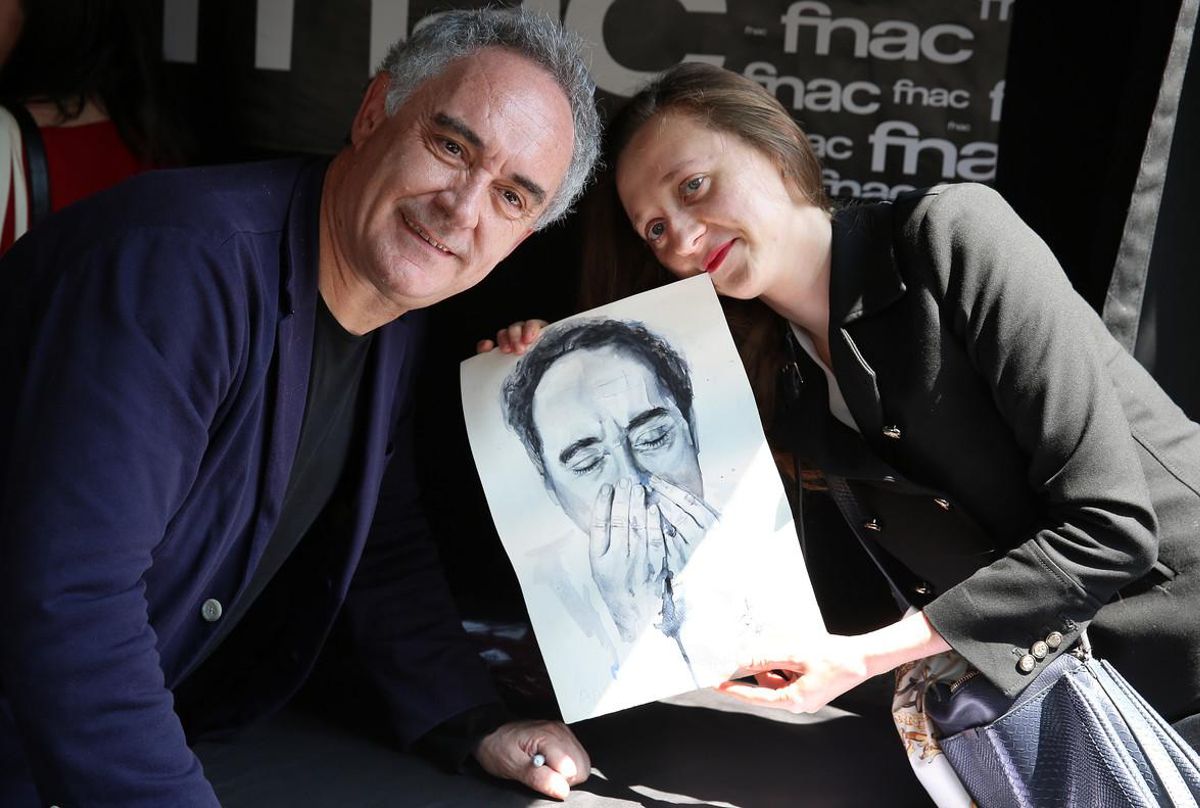 Ferran Adrià recibe el regalo de una admiradora durante la firma de libros. 