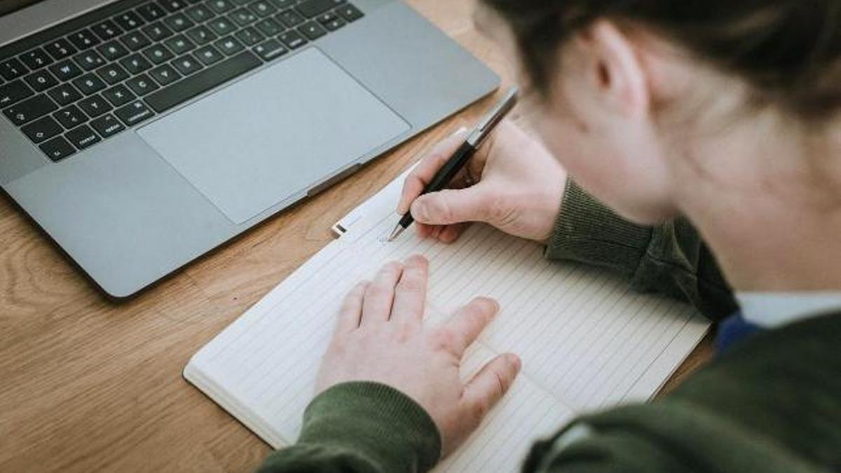 Una estudiante, en la biblioteca mientras se prepara un examen