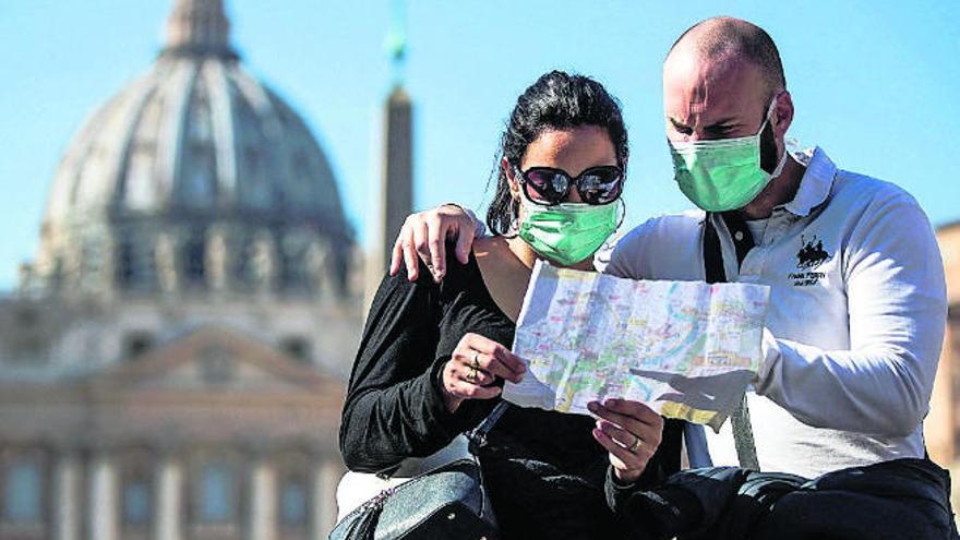 Dos turistas consultan un mapa ante la Basílica de San Pedro (Vaticano).