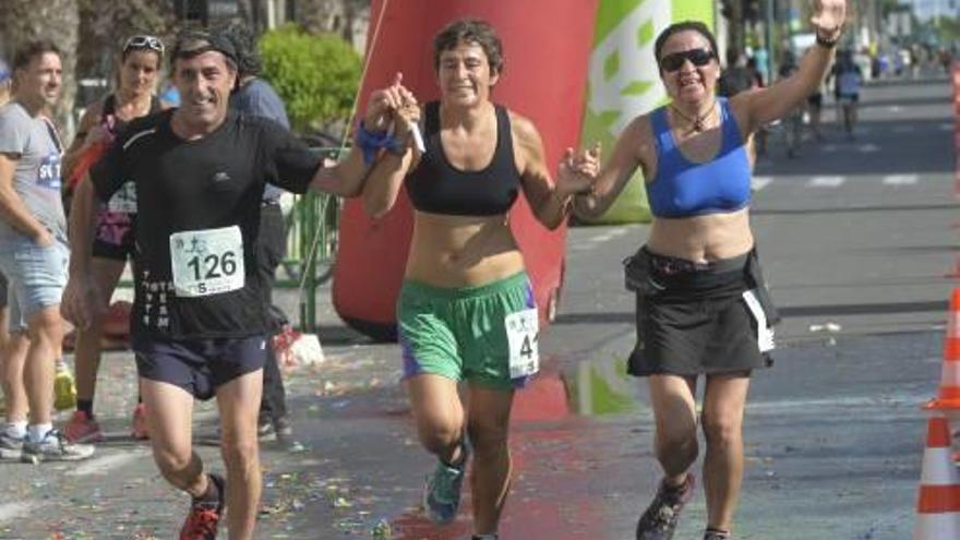 Tres personas cogidas de la mano tras el paso por uno de los puntos del tramo de asfalto.