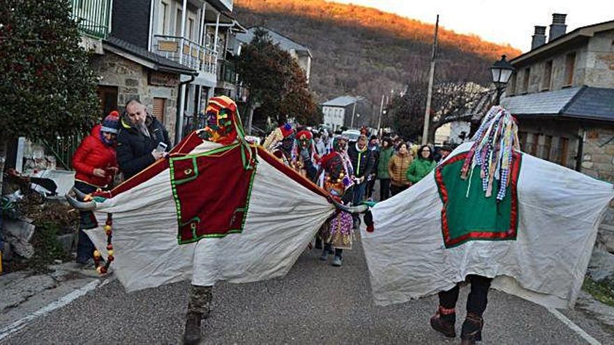 Vecinos y turistas de San Martín de Castañeda acompañan a Visparros, Talanqueiras y otros personajes de la comitiva por la travesía del pueblo .