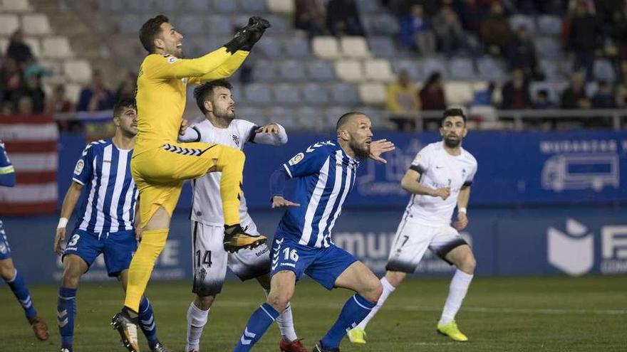 Dorronsoro despeja un balón presionado por Rubén García y con Santos en segundo plano.