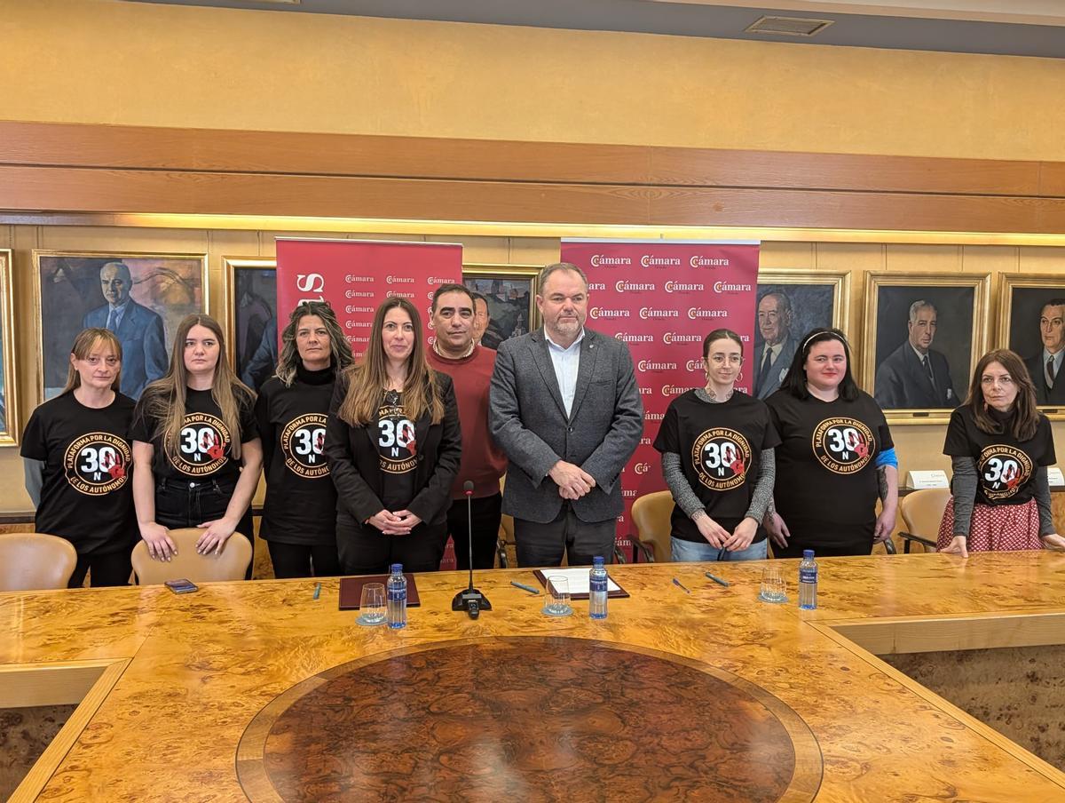 Carlos Paniceres, en el centro flanqueado por Carmen Corredor y Ángela Menéndez y junto a miembros de la plataforma