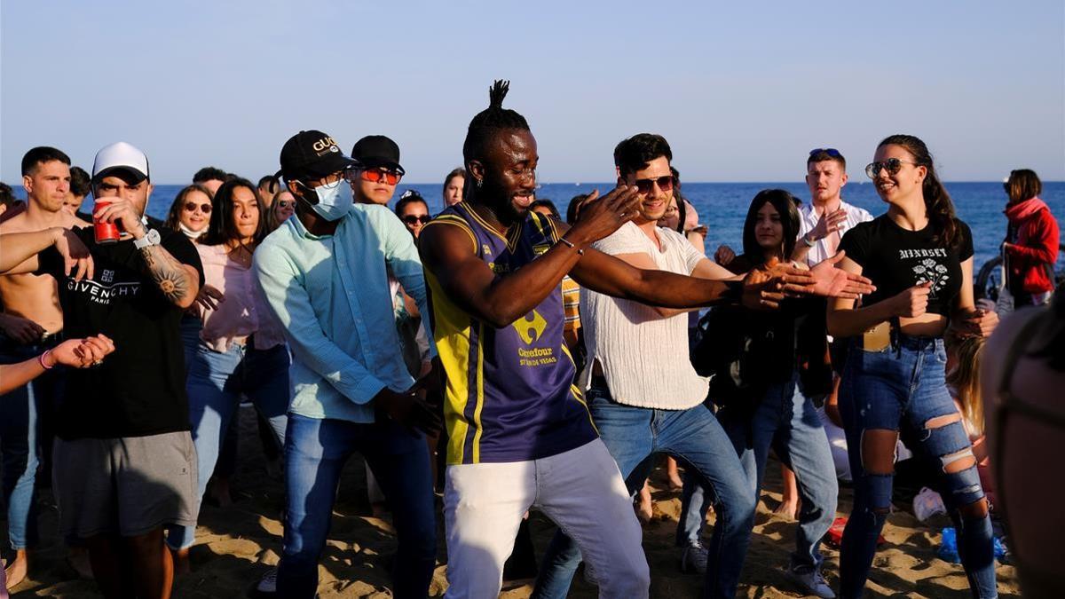 People dance at Barceloneta beach  amid the coronavirus disease (COVID-19) outbreak  in Barcelona  Spain April 2  2021  REUTERS Nacho Doce