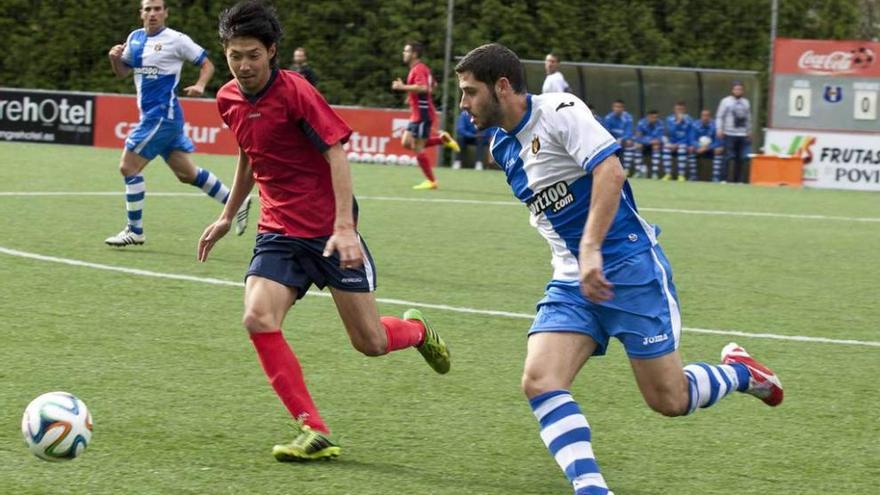 El arlequinado Villa conduce el balón perseguido por Yomei del Cudillero. fernando rodriguez