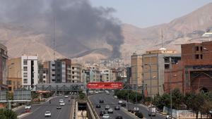 Vehículos circulan por una autopista mientras se eleva humo al fondo desde una refinería de petróleo, al noroeste de Teherán, Irán. EFE/ Abedin Taherkenareh
