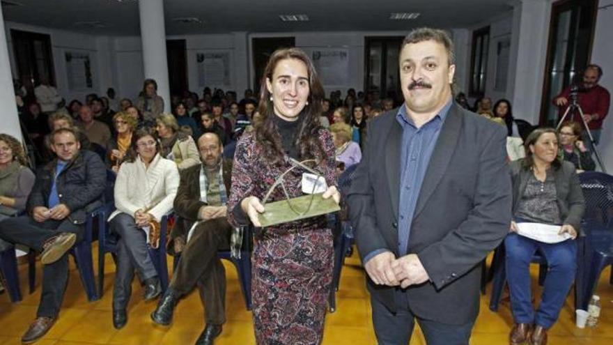Concepción Álvarez muestra el galardón junto al presidente de la Entidad Local, Urbano Esmerode.  // M.G.B.