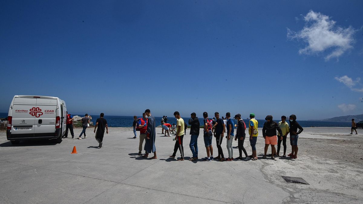 Un grupo de migrantes hace cola en Ceuta para recibir alimentos de Cáritas