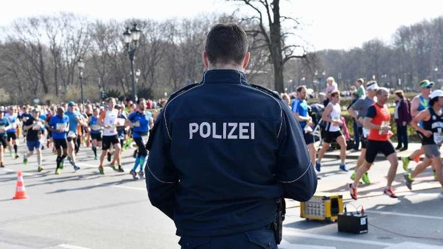 Un policía vigila el paso de los corredores por los alrededores del Tiergarten berlinés. // AFP