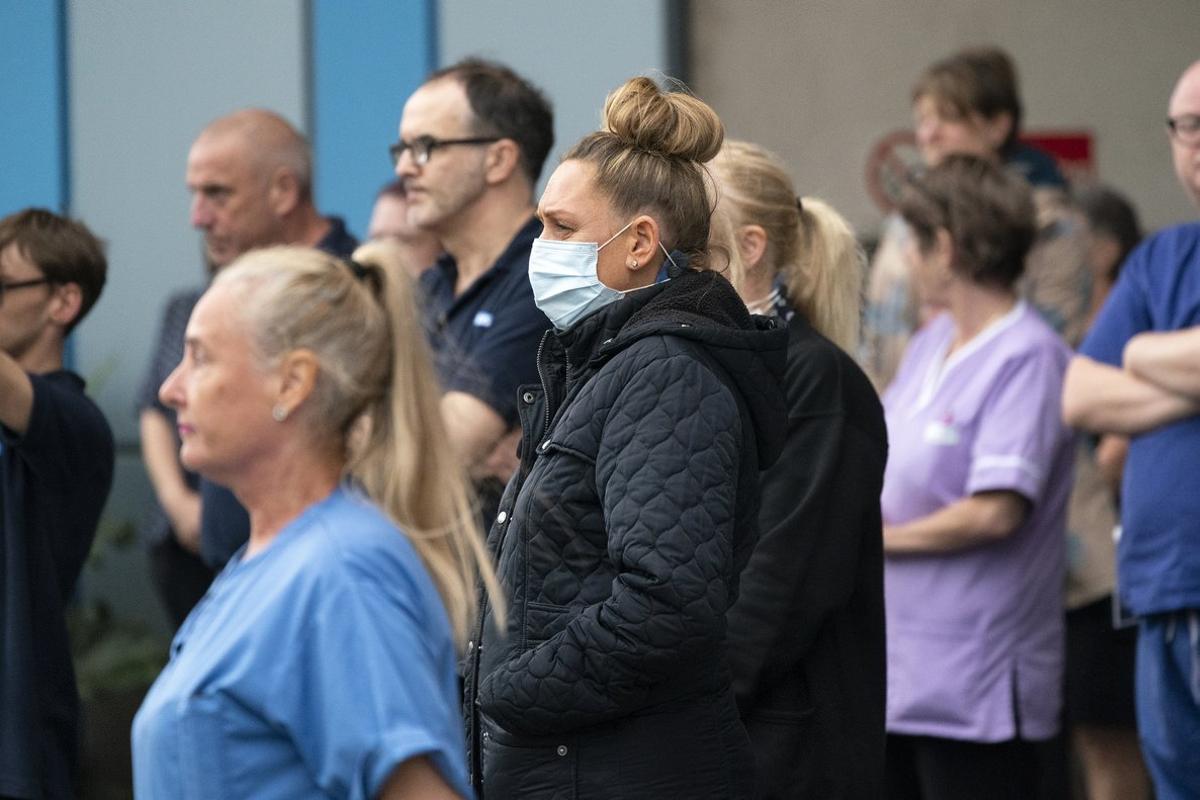 SALFORD,  UNITED KINGDOM- APRIL 28: NHS staff take part in a minute’s silence outside Salford Royal Hospital on April 28, 2020 in Salford, United Kingdom. The moment of silence, commemorating the key workers who have died during the Covid-19 pandemic, was timed to coincide with International Workers’ Memorial Day. At least 90 NHS workers are reported to have died in the last month, in addition to transport employees and other key workers. (Photo by Christopher Furlong/Getty Images)