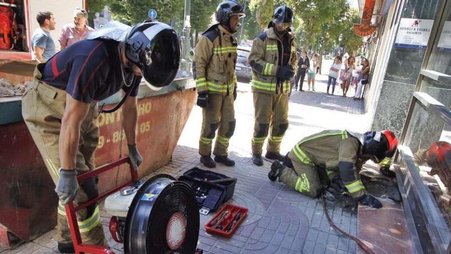 Los bomberos en el exterior del inmuelbe de Gran Vía afectado por el cortocircuito.  // Jorge Santomé