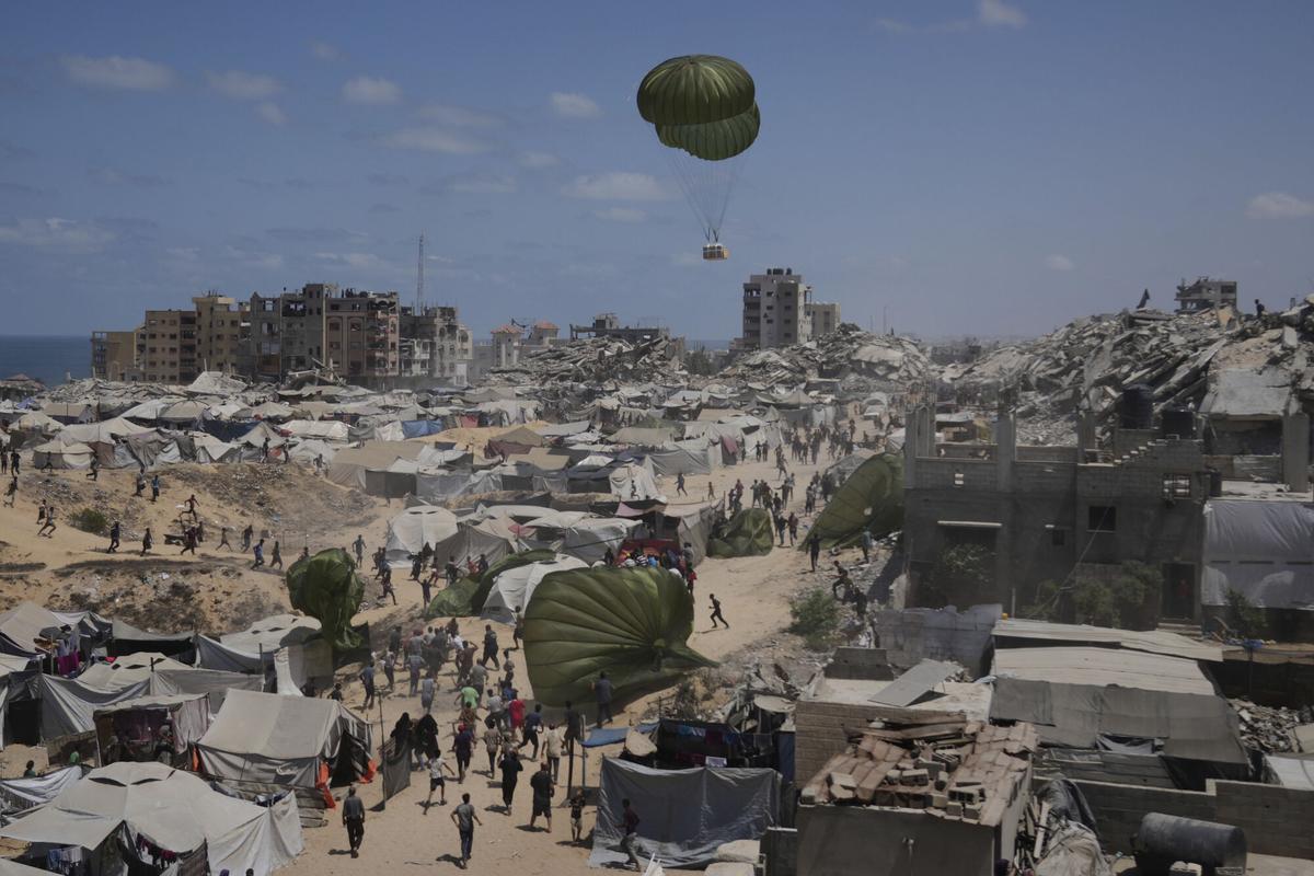 Palestinians rush to collect humanitarian aid airdropped by parachutes into Gaza City, northern Gaza Strip, Aug. 7, 2025. (AP Photo/Jehad Alshrafi) Associated Press/LaPresse. EDITORIAL USE ONLY/ONLY ITALY AND SPAIN