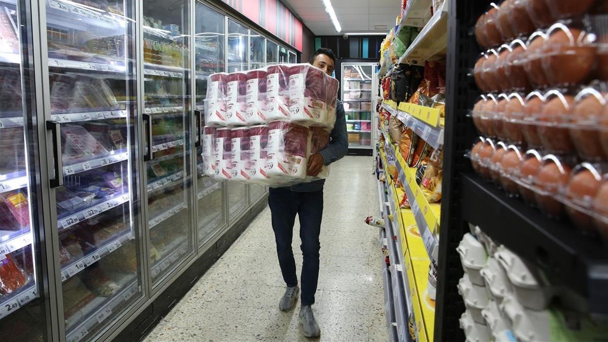 El dueño de un supermercado de Sant repone papel higiénico, ayer