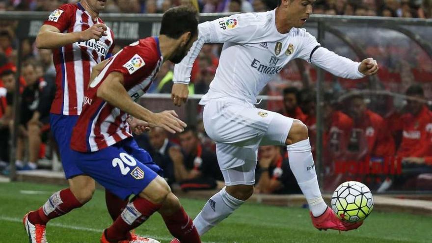 Cristiano trata de escaparse de Juanfran ante la mirada de Gabi. // Efe