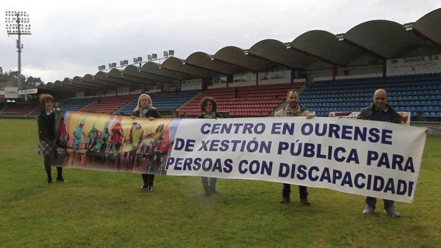 El presidente de la UD Ourense y representantes de la asociación de padres del centro de educación especial posan con la pancarta. // J.R.