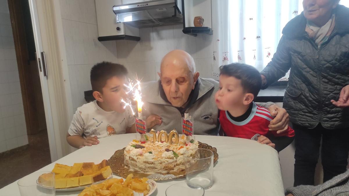 El vecino de Beluso José Otero Estévez sopla ayer las velas de sus 100 años junto a dos de sus bisnietos.