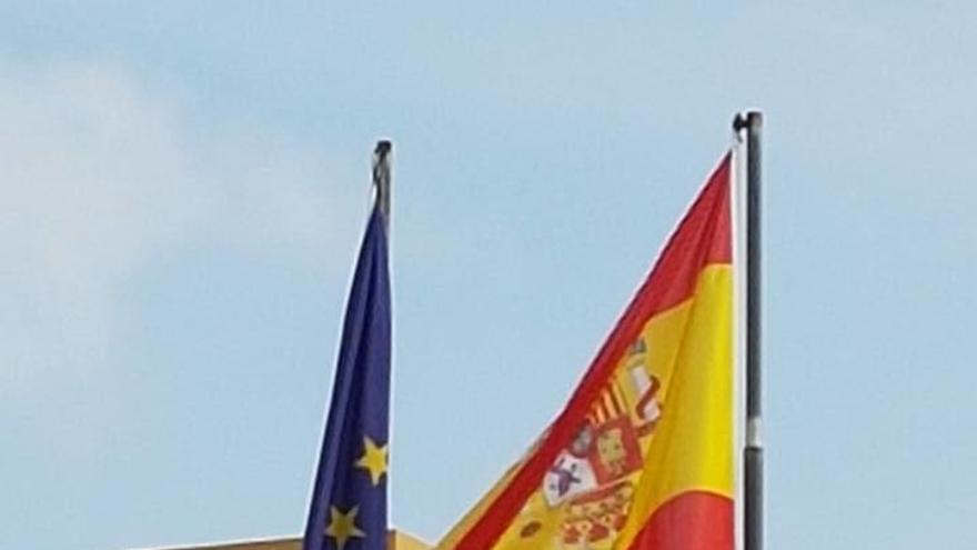 El escudo de la bandera nacional aparece del revés en el el mástil.