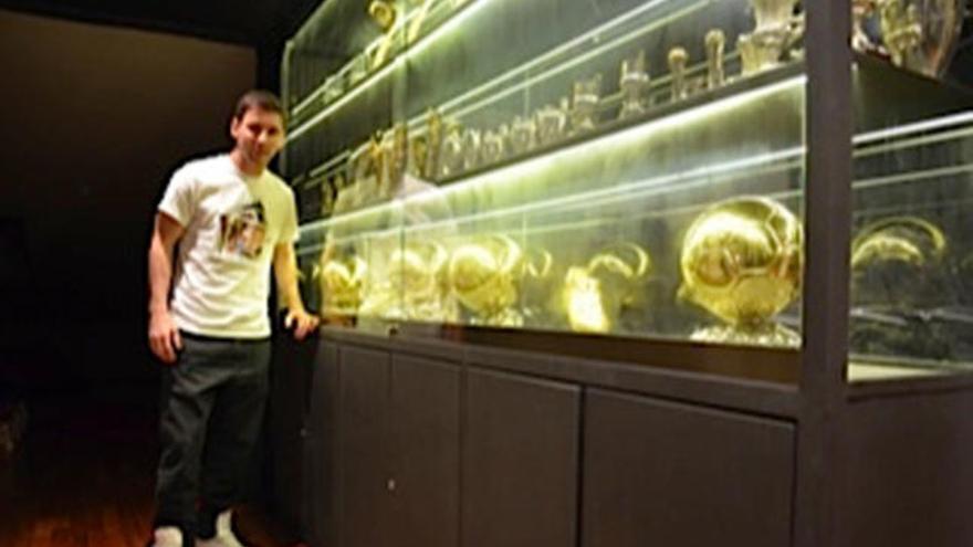 Leo Messi posa junto a sus trofeos.